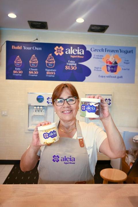 An aleia team member holding freshly packed pints of frozen yogurt
